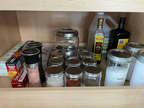 An assortment of spices, flour, sugar, oil, salt, and pepper, etc. Taken 07/2025.