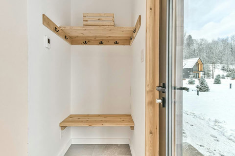 Convenient coat hooks and bench greet you at the front door.