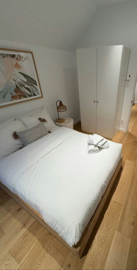 An inviting second bedroom with soft linens and convenient wardrobe storage. Taken 2025