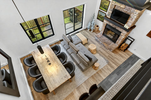 Bright great room with stone fireplace, TV, and spacious dining area