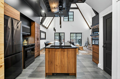 Modern A-frame kitchen with vaulted ceilings and cozy stone fireplace