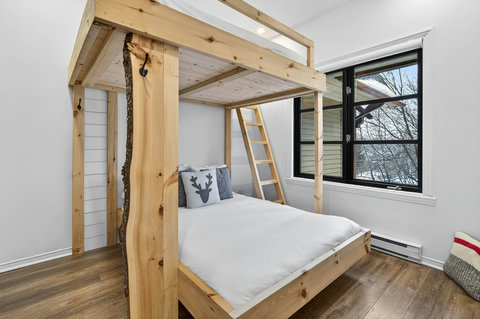 Rustic bunk room with custom woodwork and bright scenic windows