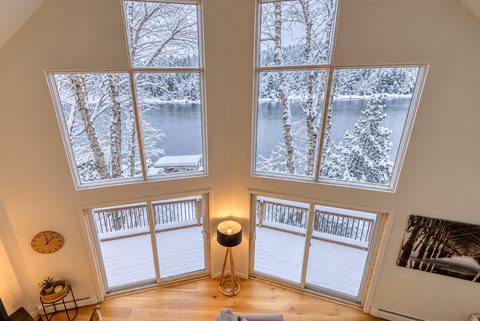 Soaring windows with breathtaking snowy lake views and deck access
