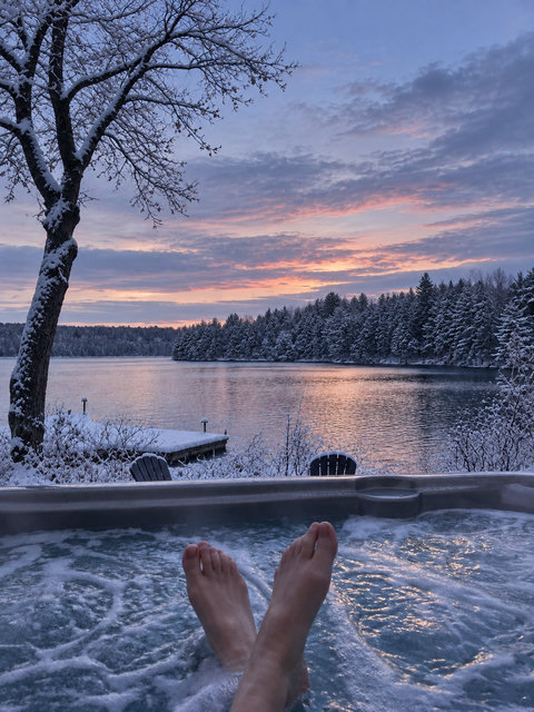 Soak in the hot tub with lake views and a stunning snowy sunset