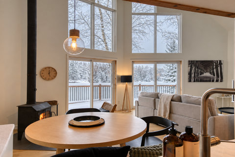 Cozy chalet-style living room with wood stove and stunning snowy views