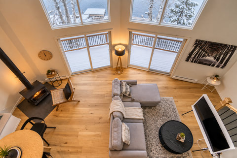 Soaring windows, lake views, and a cozy wood stove lounge