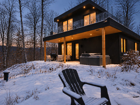 Modern forest cabin with hot tub, balcony, and cozy winter ambiance