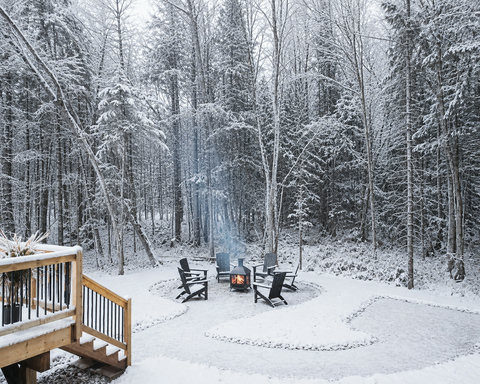 Cozy fire pit and forest views in a serene snowy backyard