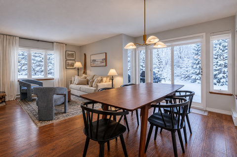 Bright dining and living space with snowy backyard views