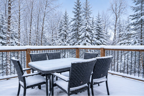 Private snowy deck with outdoor dining and peaceful forest views