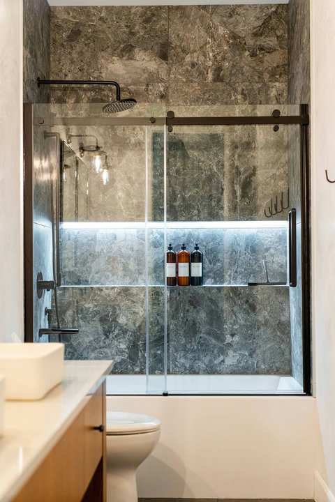 Spa-style bathroom with marble-look tile and sleek glass shower