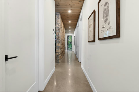 Bright designer hallway with stone accents and warm wood ceiling