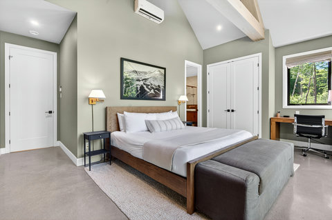 Bright vaulted bedroom with workspace, bench seating, and serene modern style