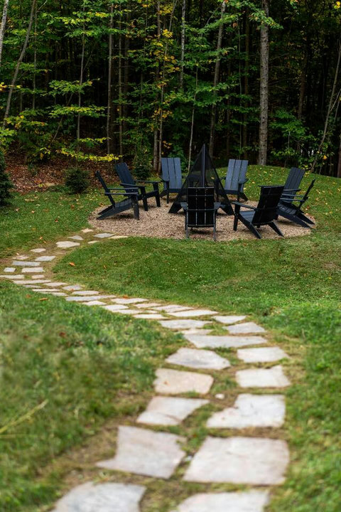 Outdoor fire pit with Adirondack chairs.
