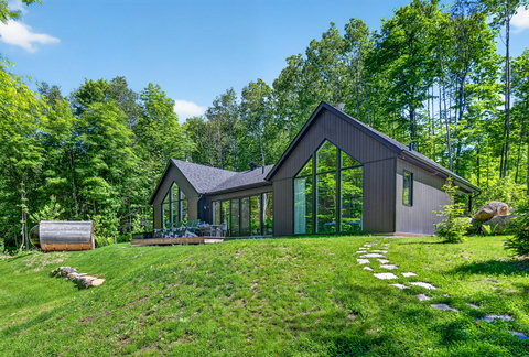 Modern forest retreat with panoramic windows and a peaceful outdoor deck