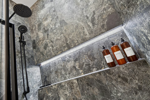 Spa-style stone shower with rainfall head and sleek modern finishes