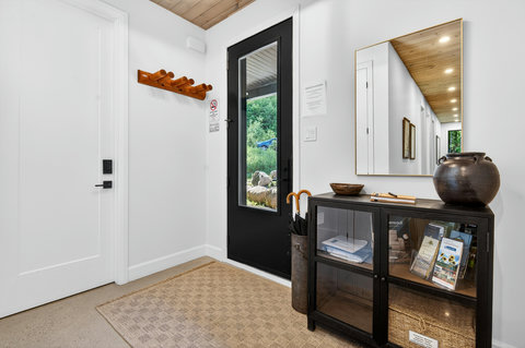Bright modern entryway with stylish storage and nature views