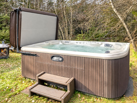 Private outdoor hot tub surrounded by peaceful woodland views