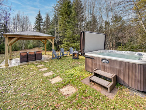 Private hot tub, gazebo seating, and a peaceful wooded backyard retreat