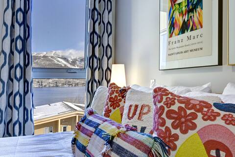 Colorful cozy bedroom with stunning mountain and lake views
