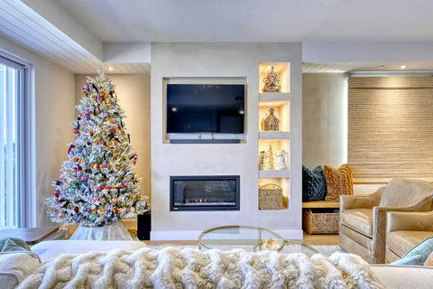 Cozy modern lounge with fireplace, TV, and festive holiday charm