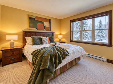 Cozy bedroom with plush bedding and serene snowy views