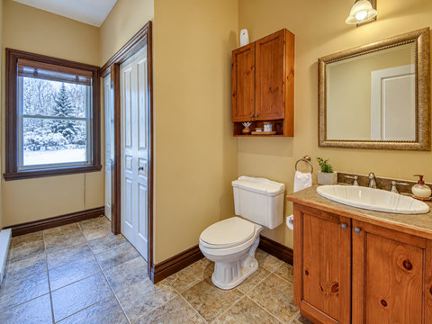 Spacious rustic bathroom with warm wood finishes and scenic winter views