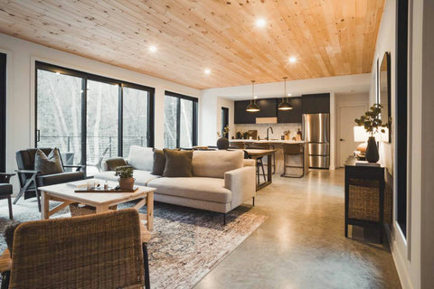 Cozy up in the designer living room with panoramic views of the forest. The perfect spot to unwind after a day full of activities with your loved ones.