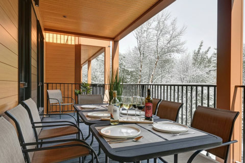 Covered balcony dining with serene snowy forest views