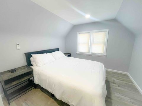 Queen size bed, independent split air conditioning cooling and heating unit, night stand on each side of the bed with USB charging ports and outlets, large wardrobe closet, and a dresser. 