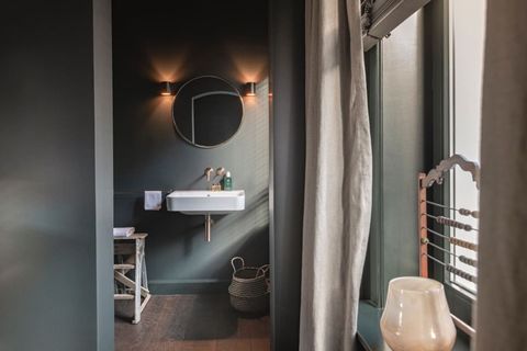Bathroom entrance with sink, shower, toilet  and utilities.