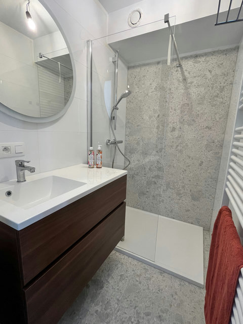 Moderne badkamer met ruime inloopdouche en frisse afwerking, ideaal voor een ontspannen start van de dag.