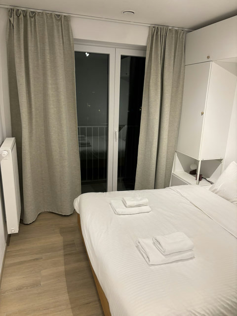 Gezellige slaapkamer met rustgevende tinten en veel licht, perfect voor een comfortabele nachtrust.