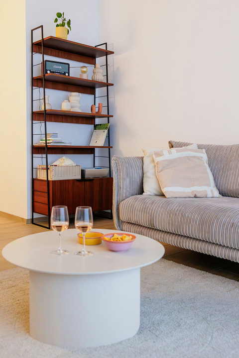 Stijlvolle en huiselijke woonkamer met warme accenten en een uitnodigende sofa om heerlijk te ontspannen.