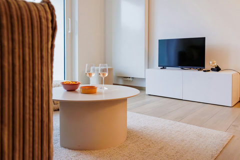 Knusse leefruimte met een minimalistisch design, perfect om te genieten van een drankje of een gezellige tv-avond.