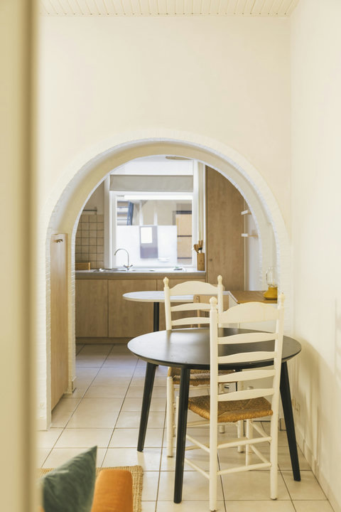 White brick archway leading from the dining area into the fully equipped kitchen