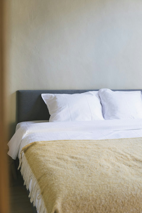 Crisp white hotel-quality bedding with a soft wool throw for cool Bruges evenings
