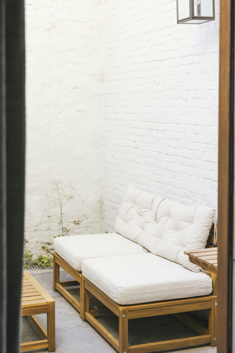 Private sun-trap courtyard with comfortable lounge seating — enjoy your morning coffee outdoors