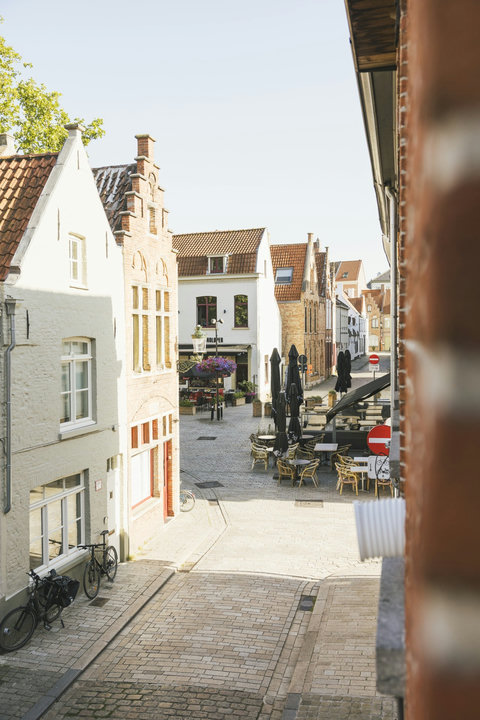 The view from the house: cobbled streets, café terraces and gabled houses of historic Bruges at your doorstep