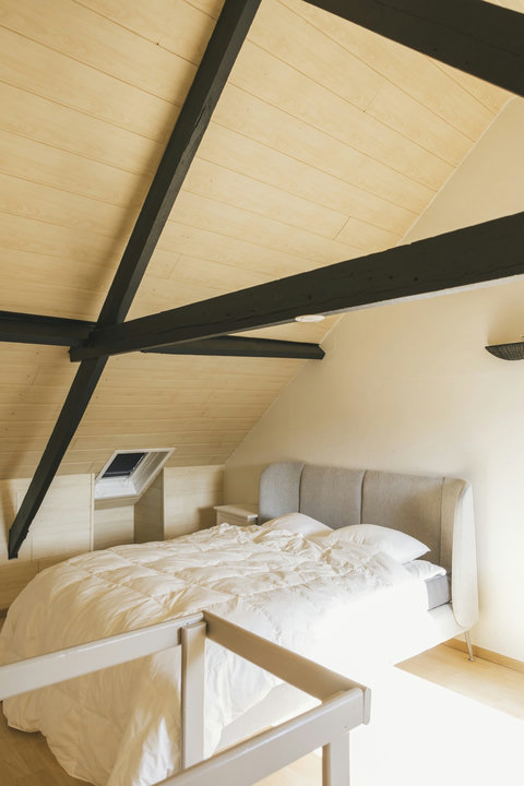 Romantic attic bedroom under original exposed beams — a favourite with couples