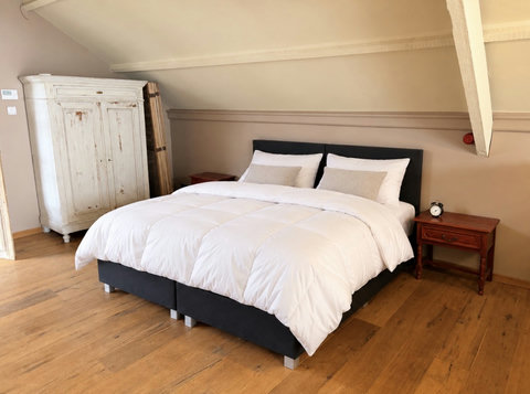 Slaapkamer met een comfortabel tweepersoonsbed, geschikt voor 2 gasten. De kamer ligt op de bovenverdieping en heeft charmante houten vloeren.