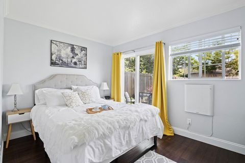 The guest house's separate bedroom features queen-size bed, blackout and semi-sheer curtains, desk, wall-mounted TV and wardrobe, with a private patio area right outside sliding glass doors.