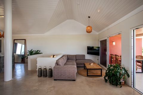 Large stylish living room with big TV and high ceilings.