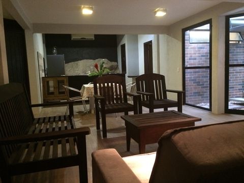 Estúdio com 70m2 climatizados, fotografia mostra a Sala de Estar com Sofá Cama e Cozinha ao fundo.