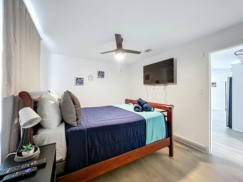 Bedroom with Queen bed with smart Tv and closet