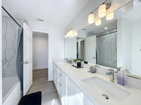 Full bathroom with two sinks  a hut tub toilet and direct access to the pool and backyard.
