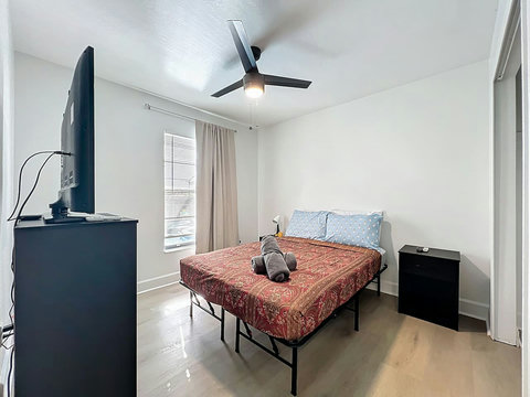 Bedroom with full bed with smart Tv and closet
