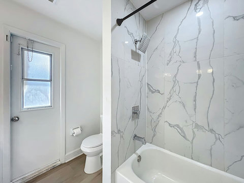 Full bathroom with two sinks  a hut tub toilet and direct access to the pool and backyard.