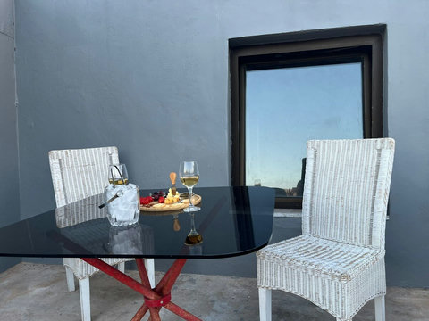 A more secluded outside sitting area with a glass table with shelter. 