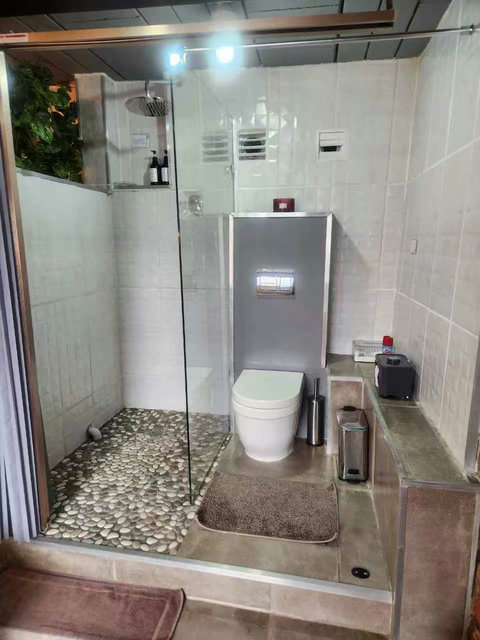 A folding door separates the bathroom from the bedroom, providing practical privacy. Two small steps are need to access shower and toilet. 